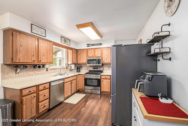 1614 N Eifert Rd, Holt, MI 48842 - kitchen featuring appliances with stainless steel finishes, dark wood-style flooring, light countertops, backsplash, and brown cabinetry