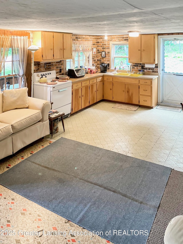 103 Norway Rd, Roscommon, MI 48653 - kitchen with white electric range oven, light flooring, backsplash, light countertops, and light brown cabinetry