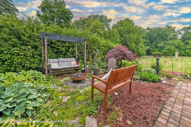 13689 Oneida Rd, Grand Ledge, MI 48837 - view of yard with a fire pit, a pergola, and view of wooded area