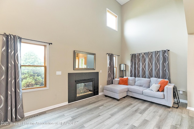 13689 Oneida Rd, Grand Ledge, MI 48837 - living area featuring light wood-style flooring, a towering ceiling, and a fireplace