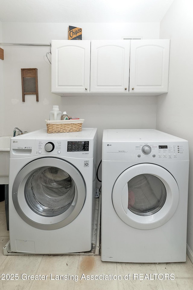 13689 Oneida Rd, Grand Ledge, MI 48837 - laundry area featuring cabinet space and washing machine and clothes dryer