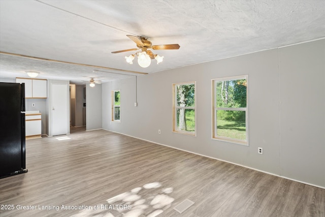 27508 F Dr S, Albion, MI 49224 - unfurnished living room with ceiling fan, light wood-type flooring, and a textured ceiling