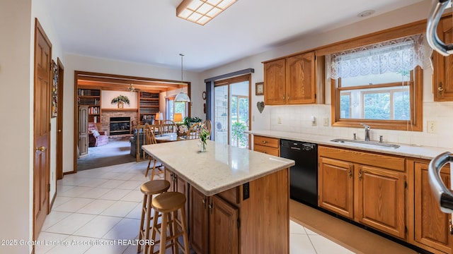 3888 Breckinridge Dr, Okemos, MI 48864 - kitchen with black dishwasher, a kitchen island, light tile patterned flooring, tasteful backsplash, and brown cabinets