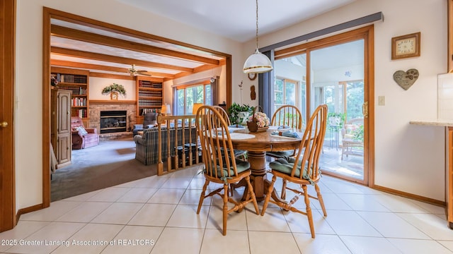 3888 Breckinridge Dr, Okemos, MI 48864 - dining room featuring a brick fireplace, beamed ceiling, a ceiling fan, light tile patterned flooring, and light carpet