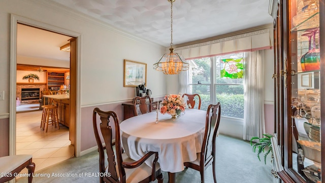 3888 Breckinridge Dr, Okemos, MI 48864 - carpeted dining room with a chandelier, crown molding, and a glass covered fireplace