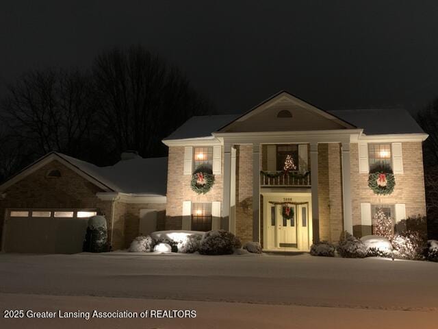 3888 Breckinridge Dr, Okemos, MI 48864 - neoclassical / greek revival house featuring a garage, brick siding, and driveway