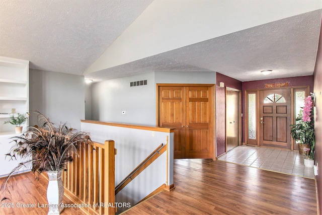 12829 Silver Ridge Dr, Grand Ledge, MI 48837 - entryway with a textured ceiling, vaulted ceiling, and wood finished floors