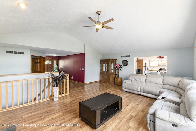 12829 Silver Ridge Dr, Grand Ledge, MI 48837 - living area featuring vaulted ceiling, a ceiling fan, and wood finished floors