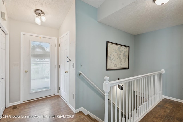 207 Queens Ct Unit 8, Grand Ledge, MI 48837 - entrance foyer with a textured ceiling and wood finished floors