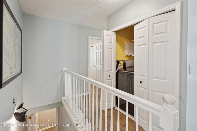 207 Queens Ct Unit 8, Grand Ledge, MI 48837 - hall featuring wood finished floors and a textured ceiling