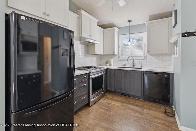 207 Queens Ct Unit 8, Grand Ledge, MI 48837 - kitchen with black appliances, under cabinet range hood, light countertops, ceiling fan, and hardwood / wood-style flooring