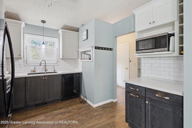 207 Queens Ct Unit 8, Grand Ledge, MI 48837 - kitchen with black appliances, dark wood-type flooring, light countertops, tasteful backsplash, and white cabinetry