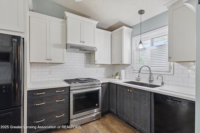 207 Queens Ct Unit 8, Grand Ledge, MI 48837 - kitchen with black appliances, under cabinet range hood, white cabinets, dark wood-style flooring, and light countertops
