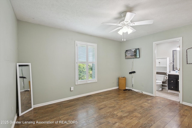 207 Queens Ct Unit 8, Grand Ledge, MI 48837 - unfurnished bedroom featuring hardwood / wood-style flooring, a textured ceiling, and ensuite bath