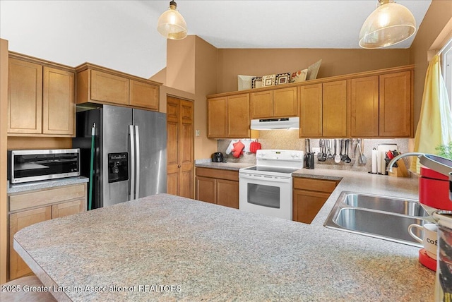 4538 Cranberry Ct, Lansing, MI 48917 - kitchen with appliances with stainless steel finishes, under cabinet range hood, light countertops, pendant lighting, and high vaulted ceiling
