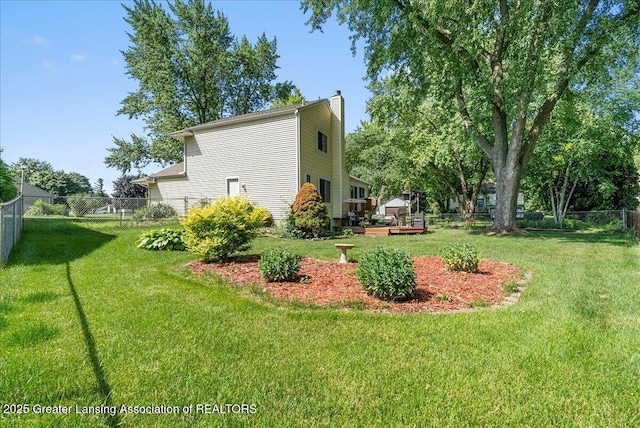 4538 Cranberry Ct, Lansing, MI 48917 - view of home's exterior with a chimney, a fenced backyard, and a wooden deck