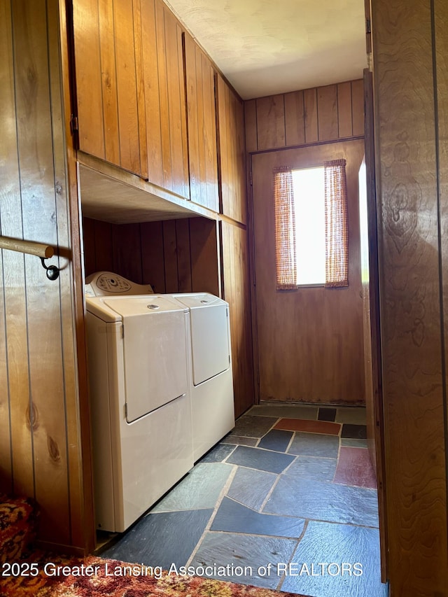 234 W Grand Ledge Hwy Unit R1, Mulliken, MI 48861 - washroom featuring cabinet space, independent washer and dryer, dark stone finish floors, and wood walls