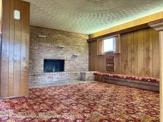 234 W Grand Ledge Hwy Unit R1, Mulliken, MI 48861 - unfurnished living room with wooden walls, a baseboard heating unit, a fireplace, and carpet