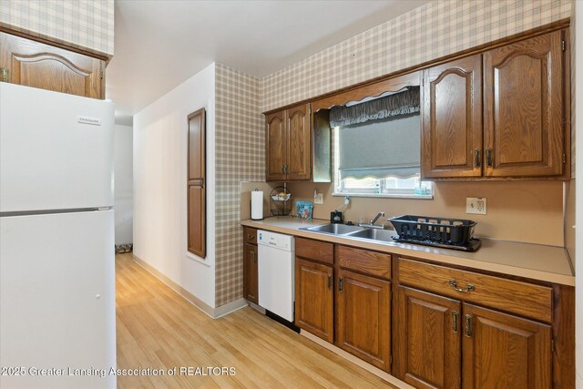 1117-1119 Blake Ave, Lansing, MI 48912 - kitchen featuring white appliances, wallpapered walls, light wood-style flooring, light countertops, and brown cabinetry