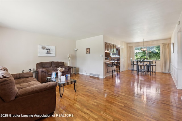 1117-1119 Blake Ave, Lansing, MI 48912 - living area with light wood-style flooring and a chandelier
