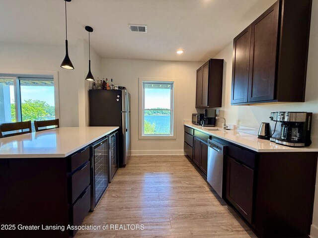 10993 Lakeside Dr, Perrinton, MI 48871 - kitchen with appliances with stainless steel finishes, wine cooler, dark brown cabinetry, healthy amount of natural light, and recessed lighting