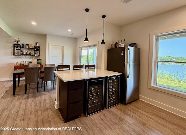 10993 Lakeside Dr, Perrinton, MI 48871 - kitchen featuring wine cooler, freestanding refrigerator, light countertops, light wood-style flooring, and recessed lighting