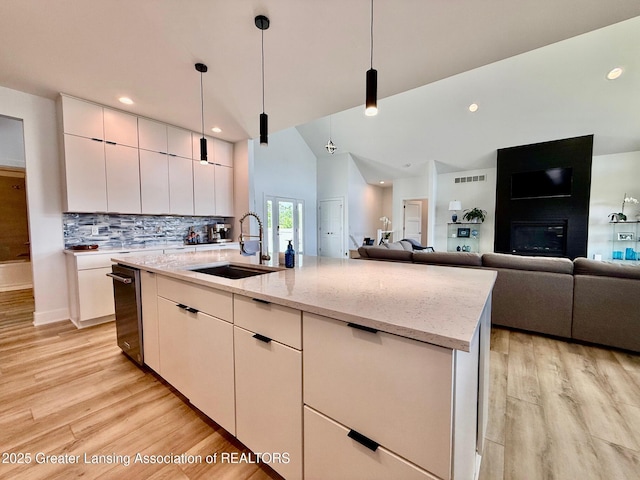 10993 Lakeside Dr, Perrinton, MI 48871 - kitchen featuring light wood-style floors, backsplash, light stone counters, pendant lighting, and recessed lighting