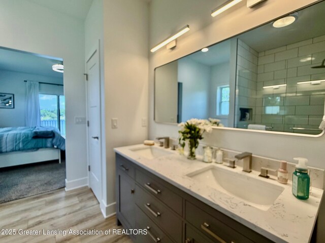 10993 Lakeside Dr, Perrinton, MI 48871 - bathroom featuring double vanity, connected bathroom, wood finished floors, a stall shower, and plenty of natural light