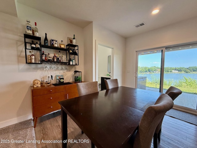 10993 Lakeside Dr, Perrinton, MI 48871 - dining area featuring a dry bar, dark wood-style floors, and recessed lighting