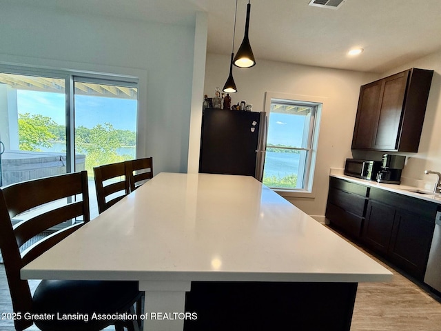 10993 Lakeside Dr, Perrinton, MI 48871 - kitchen with healthy amount of natural light, light countertops, a center island, and recessed lighting