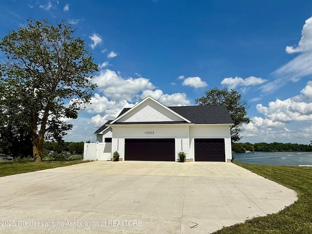 10993 Lakeside Dr, Perrinton, MI 48871 - view of front of house featuring an attached garage, driveway, and a water view