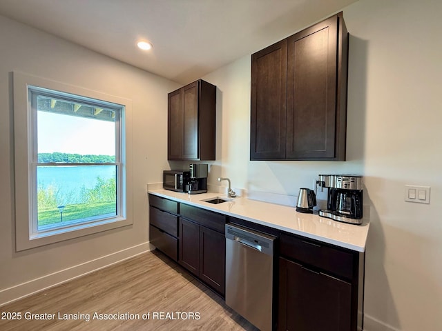 10993 Lakeside Dr, Perrinton, MI 48871 - kitchen with dishwasher, dark brown cabinetry, light wood-type flooring, light countertops, and black microwave