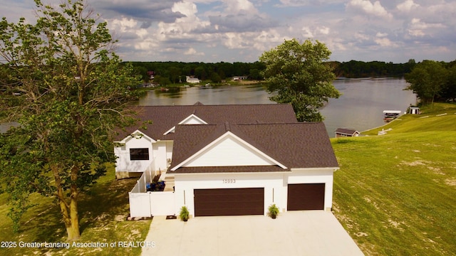 10993 Lakeside Dr, Perrinton, MI 48871 - view of front facade featuring a water view, a garage, concrete driveway, and a shingled roof