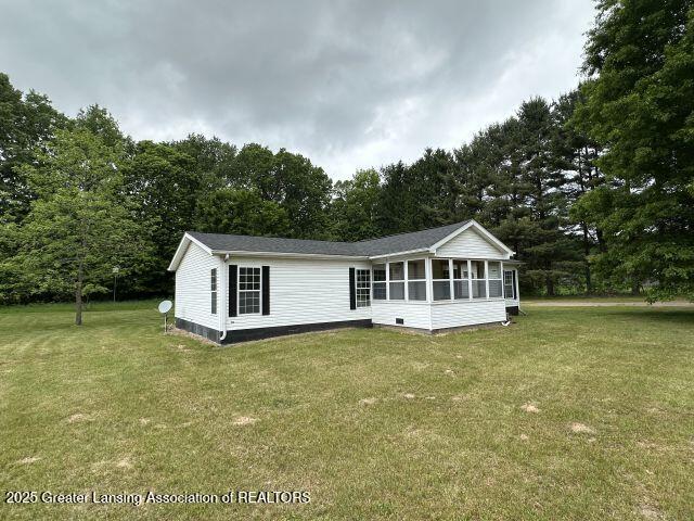 8241 Barson Rd, Rives Junction, MI 49277 - back of house featuring a sunroom, a lawn, view of scattered trees, and crawl space