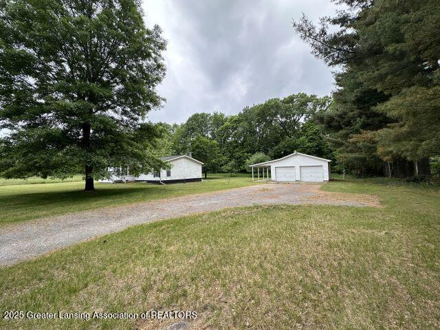 8241 Barson Rd, Rives Junction, MI 49277 - view of grassy yard with a garage and an outdoor structure