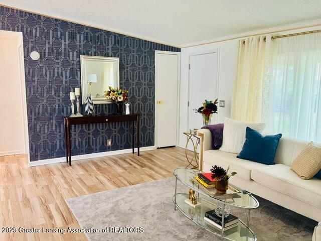4340 Balmoral Dr, Lansing, MI 48911 - living area featuring wallpapered walls, wood finished floors, and crown molding