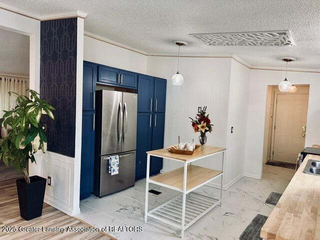 4340 Balmoral Dr, Lansing, MI 48911 - kitchen with freestanding refrigerator, blue cabinets, crown molding, a textured ceiling, and light countertops