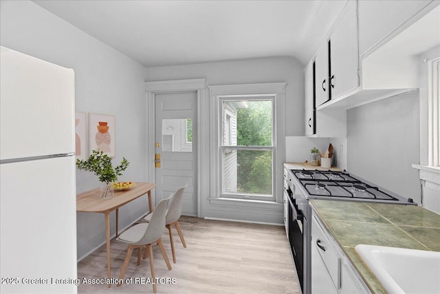 916 Wildwood Ave, Jackson, MI 49202 - kitchen featuring white appliances, white cabinets, and light wood-type flooring