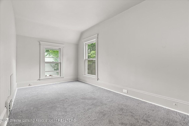 916 Wildwood Ave, Jackson, MI 49202 - carpeted empty room featuring lofted ceiling and baseboards