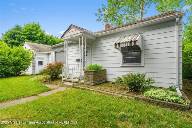 737 Jessop Ave, Lansing, MI 48910 - view of front facade featuring a front yard and a chimney