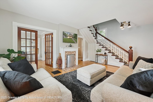 409 E Higham St, Saint Johns, MI 48879 - living area with stairway, wood finished floors, a fireplace, and french doors