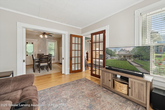 409 E Higham St, Saint Johns, MI 48879 - living area featuring french doors, light wood-style floors, crown molding, and a ceiling fan