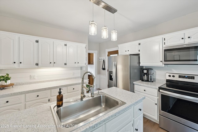 409 E Higham St, Saint Johns, MI 48879 - kitchen with stainless steel appliances, white cabinetry, hanging light fixtures, and light countertops