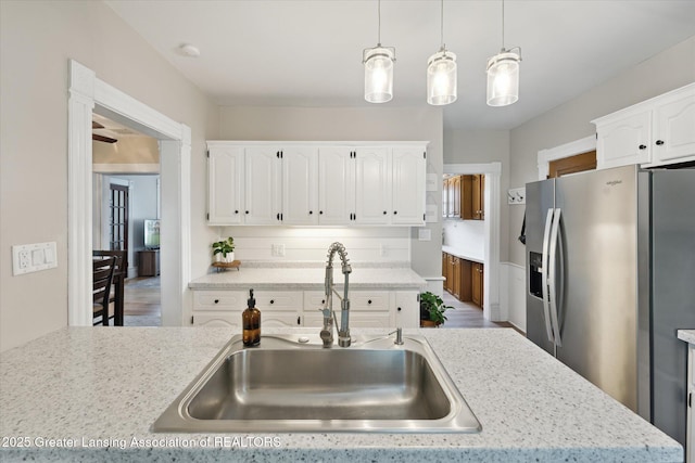 409 E Higham St, Saint Johns, MI 48879 - kitchen with stainless steel refrigerator with ice dispenser, white cabinets, and hanging light fixtures