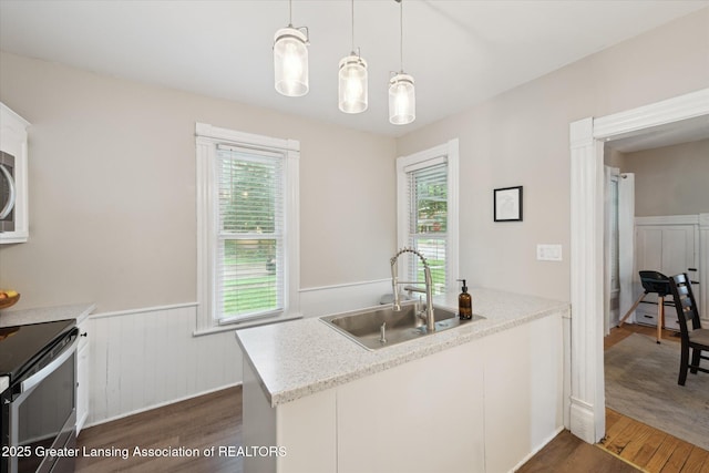 409 E Higham St, Saint Johns, MI 48879 - kitchen with dark wood-style floors, appliances with stainless steel finishes, wainscoting, and healthy amount of natural light