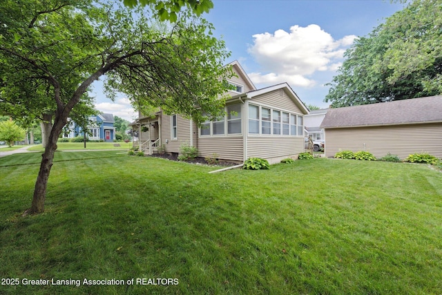 409 E Higham St, Saint Johns, MI 48879 - view of side of property featuring a sunroom and a lawn