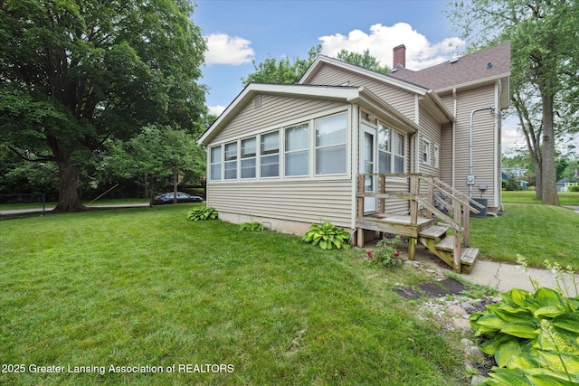 409 E Higham St, Saint Johns, MI 48879 - view of side of home featuring a chimney and a yard