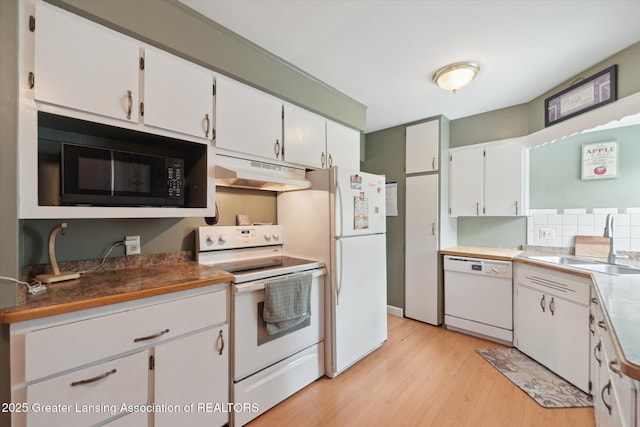 536 Hunter Blvd, Lansing, MI 48910 - kitchen featuring white appliances, under cabinet range hood, light wood-type flooring, white cabinetry, and tasteful backsplash