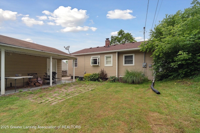 536 Hunter Blvd, Lansing, MI 48910 - back of house featuring a patio area, a lawn, and a chimney