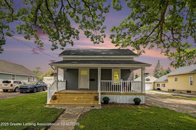 304 W Gibbs St, Saint Johns, MI 48879 - view of front facade featuring a porch, a lawn, and driveway